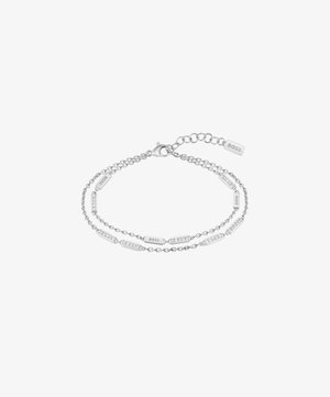 Sølv dobbeltledd armbånd med ovale lenker og rektangulære merker med "BOSS" gravering, pyntet med klare krystaller for detaljer.