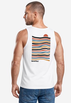 Mann in weißem ärmellosen Shirt mit bunten, wellenförmigen Streifen und einer Sonnengrafik auf dem Rücken, trägt blaue Jeans und ist abgewandt.