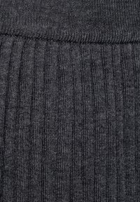 Tissu en maille côtelée gris foncé, avec une texture douce, présentant des lignes verticales et une taille lisse, adapté pour un port confortable.