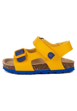 Sandale jaune avec des accents bleus, dotée d'une boucle et d'une sangle Velcro, semelle en liège et semelle en caoutchouc texturée. Design ouvert pour la respirabilité.