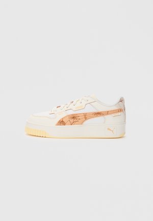 Hvid sneaker med et struktureret stof og et let orange blomster mønster på siden. Har en tyk gul sål og beige snørebånd.