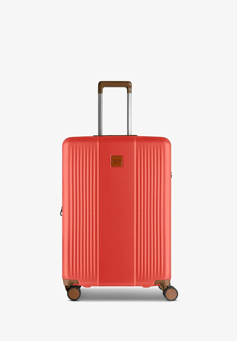 Maleta roja de concha dura con diseño estriado, mango telescópico marrón y cuatro ruedas giratorias. Presenta un pequeño logotipo en la parte frontal.