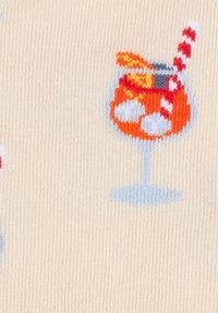 Gebreide stof met patroon van oranje cocktailglazen, ijsblokjes, sinaasappelschijfjes en rood-wit gestreepte rietjes op een beige achtergrond.