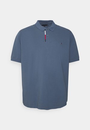 Blå polo t-shirt med korte ærmer, krave, to knapper og lille rød, hvid og sort logo på venstre bryst.