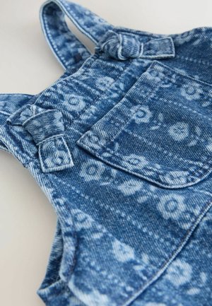 Teksapluud sinise lillemustriga, reguleeritavate rihmadega, millel on lipsuaksendid, ning esimesel taskul lisadetail.