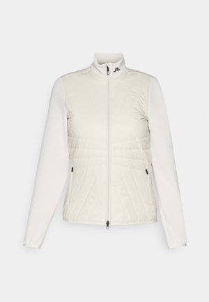 Giacca bianca con colletto alto, caratterizzata da un frontale inferiore trapuntato, maniche lisce e due tasche con zip. Logo sul collo.