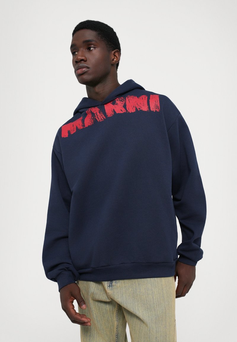 Navy blue hoodie with red graphic text across the chest. Made of soft fabric, features a drawstring hood and a relaxed fit.