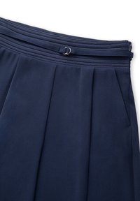 Granatowe spodnie z materiału o plisowanym kroju, z elastycznym paskiem i szlufkami na pasek. Posiadają dwie boczne kieszenie oraz gładką teksturę.