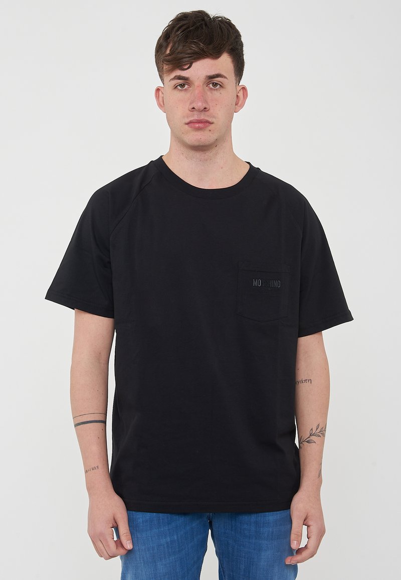 T-shirt nera in cotone con maniche corte, scollatura rotonda e taschino sul petto. Presenta un discreto dettaglio del logo sulla tasca.