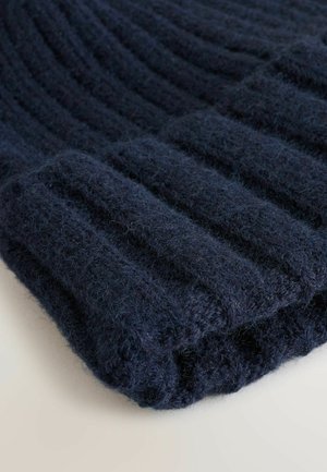 Marineblauer Strickmütze mit Rippstruktur. Hergestellt aus weichem, flauschigem Garn, verfügt sie über einen umgeschlagenen Bund und eine glatte, abgerundete Form.