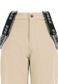 Beige broek met verstelbare zwarte bretels met een logo. De stof lijkt glad, met een voorste knoop- en ritssluiting.