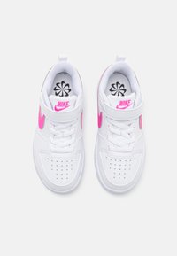 Hvite Nike sneakers med en rosa swoosh, perforert tå, snøring og velcro-rem. Teksturert læremateriale med stofffôr indeni.