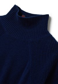 Suéter azul marino con cuello mock de canalé y paneles de punto texturizado en los hombros, extendido sobre un fondo blanco.
