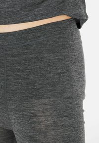 Grå stretchleggings med en slät, mjuk textur och bred midjereså. Tyget ser något melerat ut med subtila variationer.
