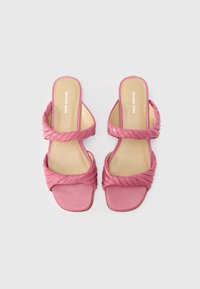 Ροζ σανδάλια με τακούνι, με σχεδιασμό στριφτής λουρίδας, δερμάτινο υλικό, τετράγωνα δάχτυλα και λεία υφή. Διαθέτουν πάτους με λογότυπο.