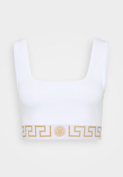 Λευκό crop top με τετράγωνη λαιμόκοψη και χοντρές τιράντες, διακοσμημένο με ένα χρυσό μοτίβο ελληνικού κλειδιού και στρογγυλό λογότυπο στην κάτω ζώνη. Μαλακό υλικό.