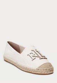 Espadrilla bianca in canvas con punta rotonda, caratterizzata da un logo metallico decorativo e una suola avvolta in juta per contrasto e texture.