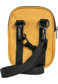 Žuta tkanina crossbody torbica s crnim trakama i metalnim detaljima. Ima zatvaranje na zip, ravni oblik i teksturiranu vanjsku površinu.