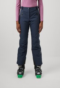 Navy ski pants with a structured design, featuring zippered pockets, adjustable waist, and reinforced cuffs. Worn with black ski boots.