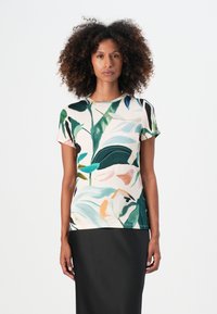 Lyhythihainen t-paita pehmeästä kankaasta, jossa on värikäs kasvitulostus vihreillä lehdillä ja pastelliväreissä kukilla, yhdistettynä mustiin hameisiin.