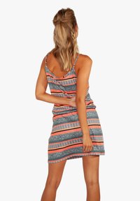 Robe sans manches avec un dos en scoop, présentant des rayures horizontales grises, roses et orange, et un motif texturé sur l'ensemble.