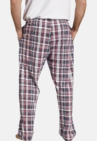 Plaid lounge pants in cotton blend, featuring red, navy, and white colors. Elastic waistband and side pockets visible, straight leg design.