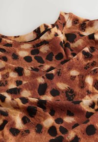 Hedvábný top v teplých hnědých tónech, s leopardím potiskem v černých a světlých béžových skvrnách; texturovaný a drapý design.