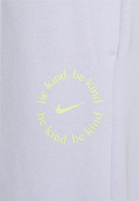 Světle levandulová mikina je ze switche s oblíbeným kulatým potiskem obsahujícím nápis "buď laskavý" a logo Nike ve výrazné žluté barvě.