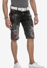 Grijze denim shorts met meerdere ritszakken, rode accenten en een gestructureerde afwerking, gecombineerd met een witte geperforeerde riem.