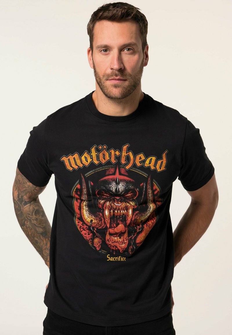 Sort bomulds T-shirt med et grafisk motiv af et vredt væsen med horn og tænder, accentueret med rød og gul tekst mærket "Motörhead."