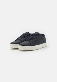Baskets en cuir bleu marine présentant une texture lisse, un bout arrondi, une semelle en caoutchouc blanche et des lacets assortis pour un maintien sécurisé.
