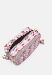 Malá obdélníková crossbody taška se vzorem geometrického chevronu v růžové, červené a levandulové barvě na bílém pozadí a zlatými zipovými akcenty.