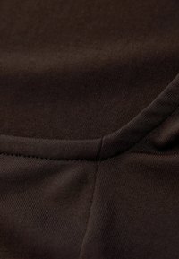 Dark brown fabric with a smooth texture, featuring a subtle ribbed pattern and reinforced stitching along the edges.