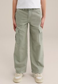 Gaiši zaļas kravas bikses ar sānu kabatām, izgatavotas no kokvilnas. Vaļīga piegriezte un taisna kāju forma, ar rāvējslēdzēju un pogu aizdari.