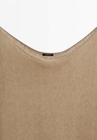 Beige stickad tröja med bred rund halsringning och en liten svart etikett inuti kragen med texten "Massimo Dutti."