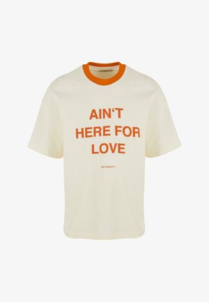 Kreemist puuvillast t-särk, millel on oranž soonikrae ja julge tekst: "EI OLE SIIN ARMUST" särkide esiküljel keskel. Moodne vabalt langev lõige.