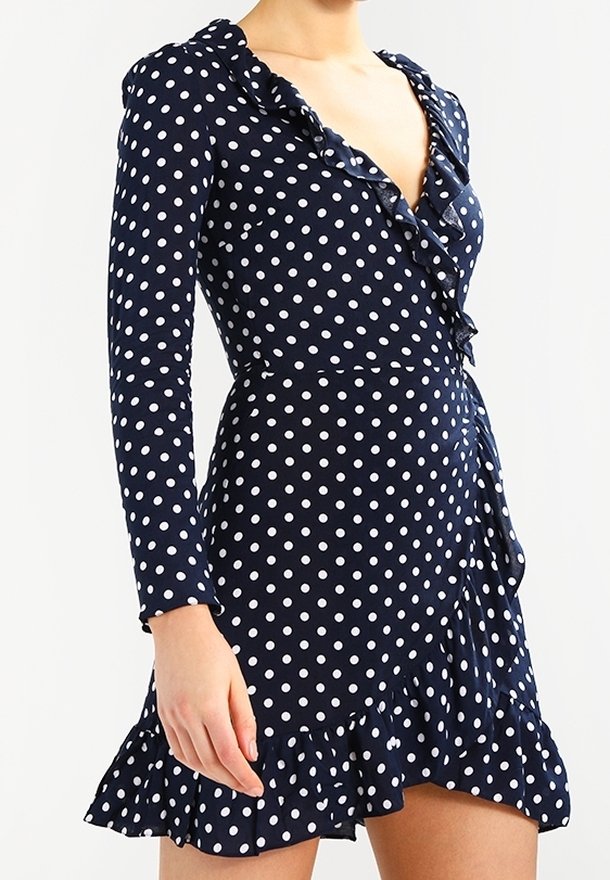 Námořnické šaty s puntíky, dlouhými rukávy, volánkovým výstřihem a lemem, s designem do zavinování, které mají bílé puntíky a mírně rozšířenou sukni.