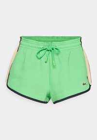 Gröna sportshorts med dragsko i midjan, med svarta kantband och en sidopanel i beige. Logotyp på vänster framsida.