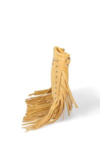 Pochette en suède beige avec des franges longues sur les côtés et des clous en argent à l'avant, se tenant droite sur un fond blanc.