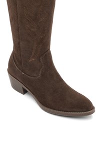 Brown suede cowboy boot with stitched flame-like decorative pattern and low stacked heel on a white background.