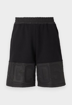 Pantaloni corti neri con una cintura elastica, caratterizzati da un tessuto superiore liscio e una sezione inferiore lucida a contrasto con grande scritta "GCSD".