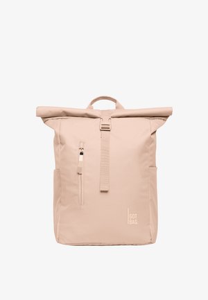 Beżowy plecak typu roll-top z przednią kieszenią na zamek, centralnym paskiem z klamrą, bocznymi kieszeniami, górnym uchwytem i logo „GOT BAG.” w dolnym prawym rogu.