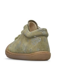 Zapato de ante verde con un cuello alto, que presenta un ligero patrón de varios animales, suela de goma y puntera redondeada. Detalles texturizados en la superficie.