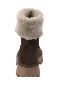 Bruine suède enkellaarzen met een crèmekleurige kunstbontmanchet, dikke bruine zool en zichtbare stikseldetails bij de hiel.