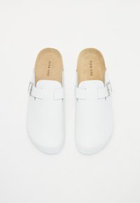 Saboți albe din material neted, cu spate deschis și un cataramă pe lateral. Tălpile interioare sunt de culoare bej, cu inscripția "PIER ONE" imprimată pe ele. Design minimalist.