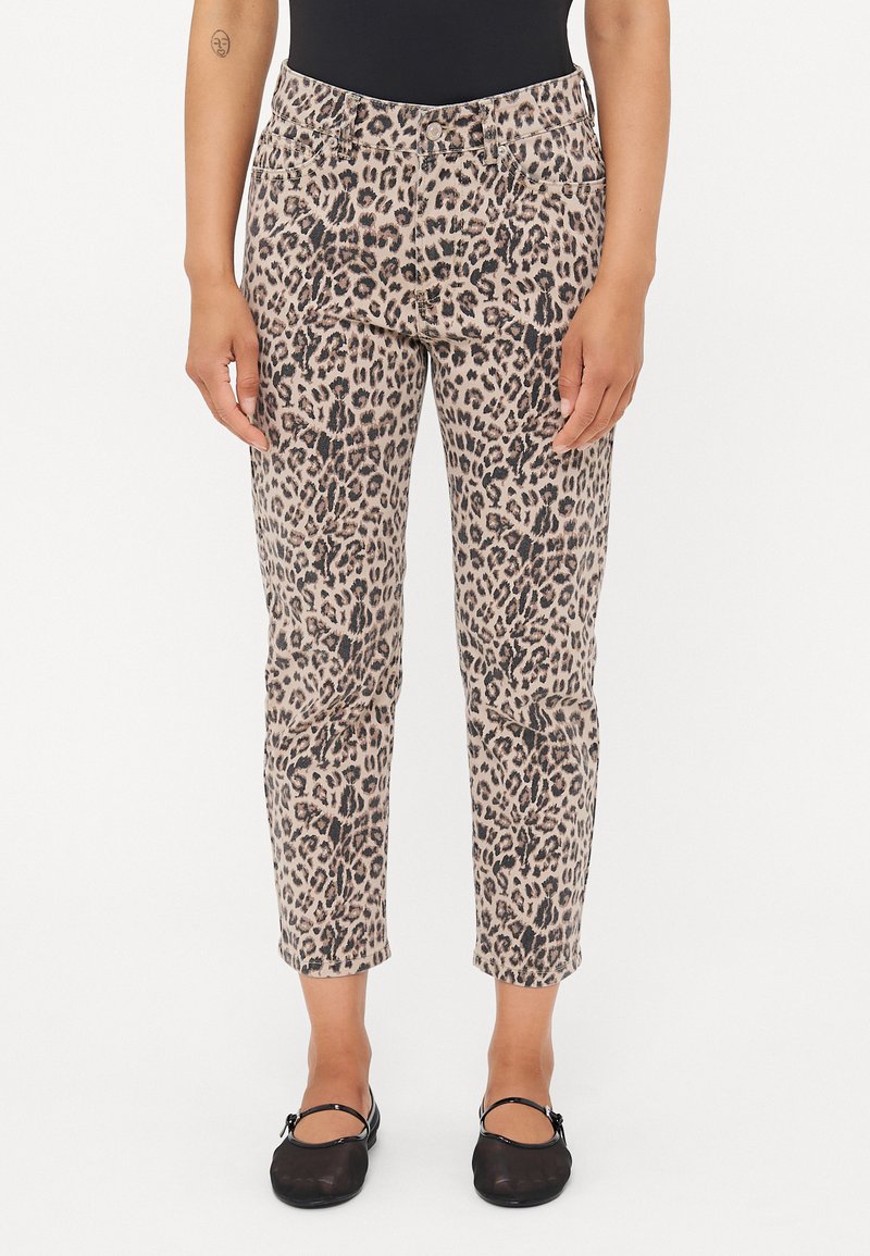 Pantalones de estampado de leopardo con un fondo beige neutro y manchas marrones oscuras, con un corte ajustado y largo hasta los tobillos.