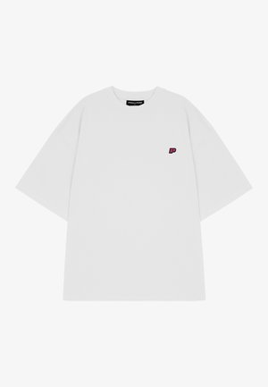 Fehér, nagyméretű pamut póló. Kicsi rózsaszín "P" logó található a bal mellen. Rövid ujjú és kerek nyakú.