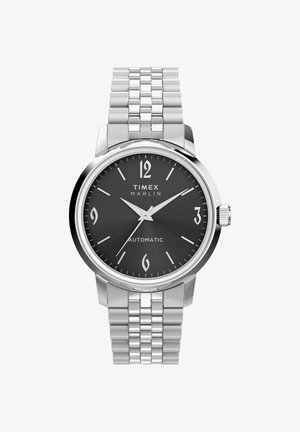 Timex Marlin automatisch horloge met zwarte wijzerplaat, zilverkleurige kast en armband, Arabische cijfers op 12, 3, 6, 9, en zilverkleurige wijzers.