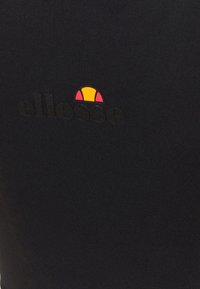 Černá látková košile s výrazným černým logem "ellesse" a vícebarevným slunečním symbolem se žlutými a růžovými akcenty.