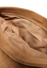 Hnedý semišový interiér tašky s hladkým svetlohnedým podšívom. Okraje majú čisté švy, čo zdôrazňuje jemnú textúru a elegantný dizajn.